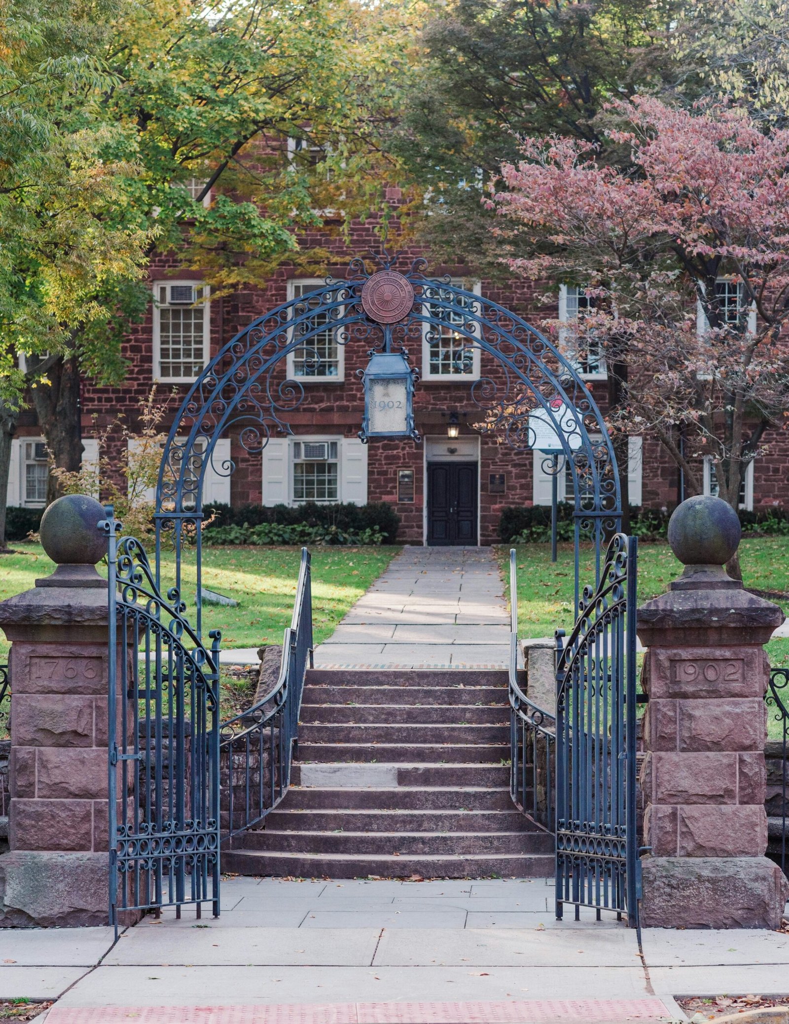 a gated entrance to a brick building with a clock on it